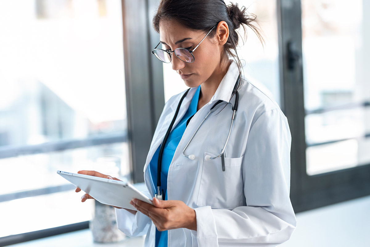 healthcare professional using a laptop in a sunny room