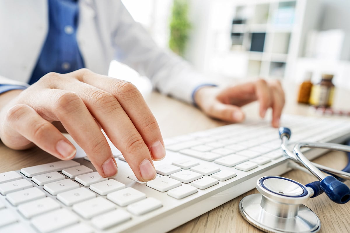 Female doctor typing on computer