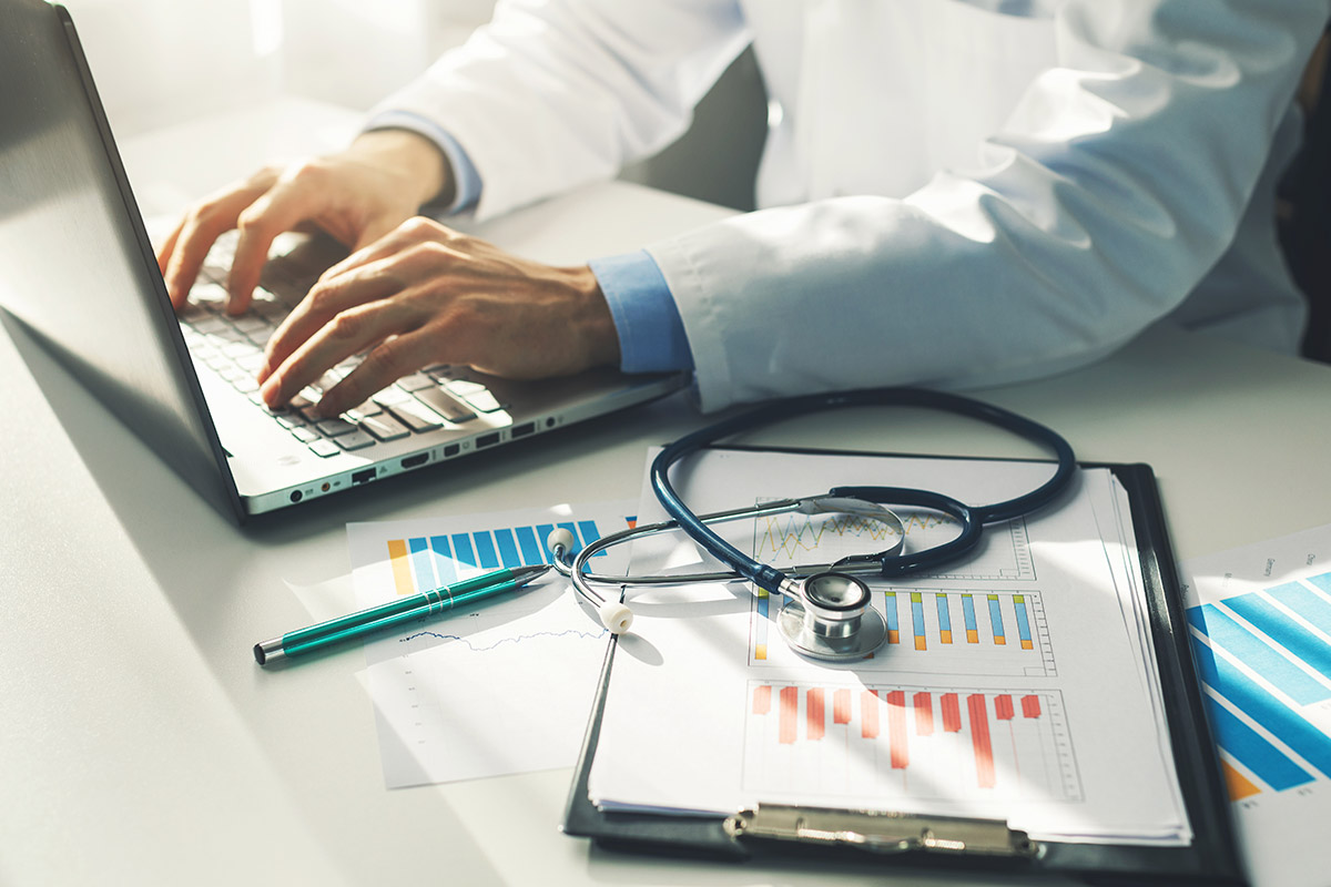 doctor typing on laptop computer in medical office