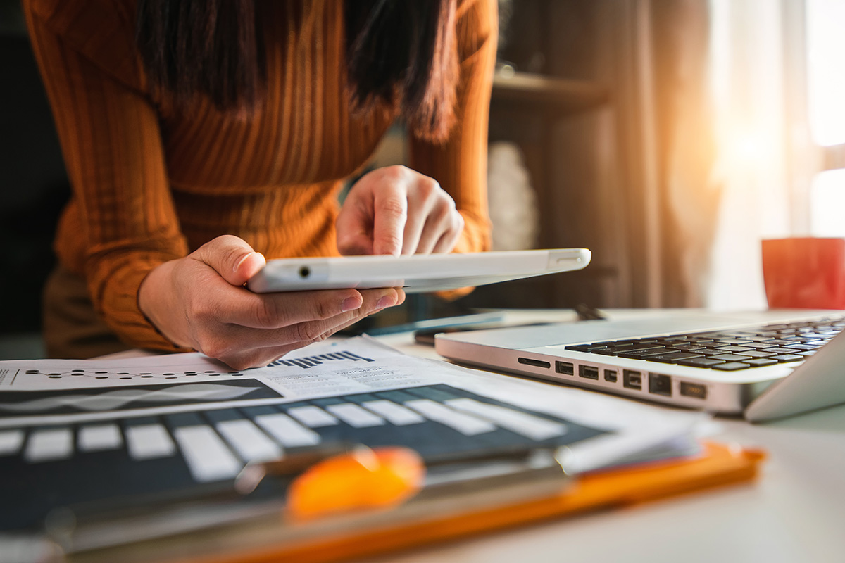 person using tablet over their desk