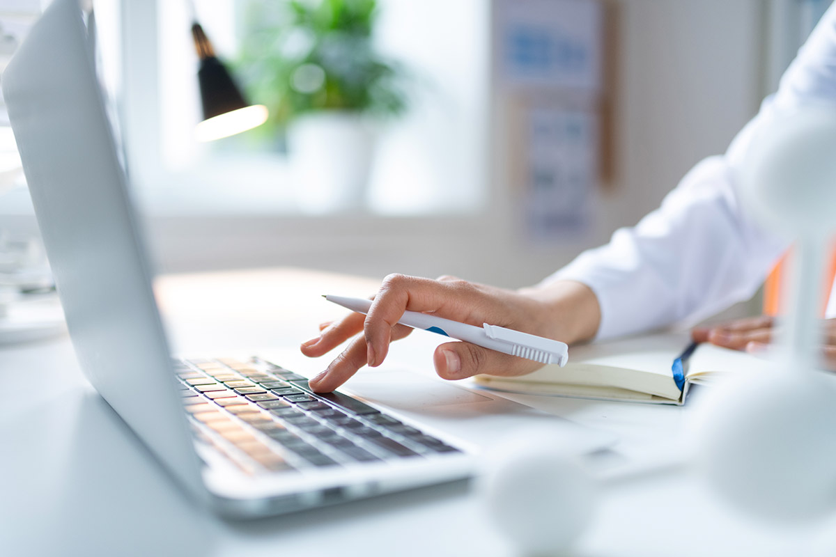 a doctor on a laptop in a lab coat 