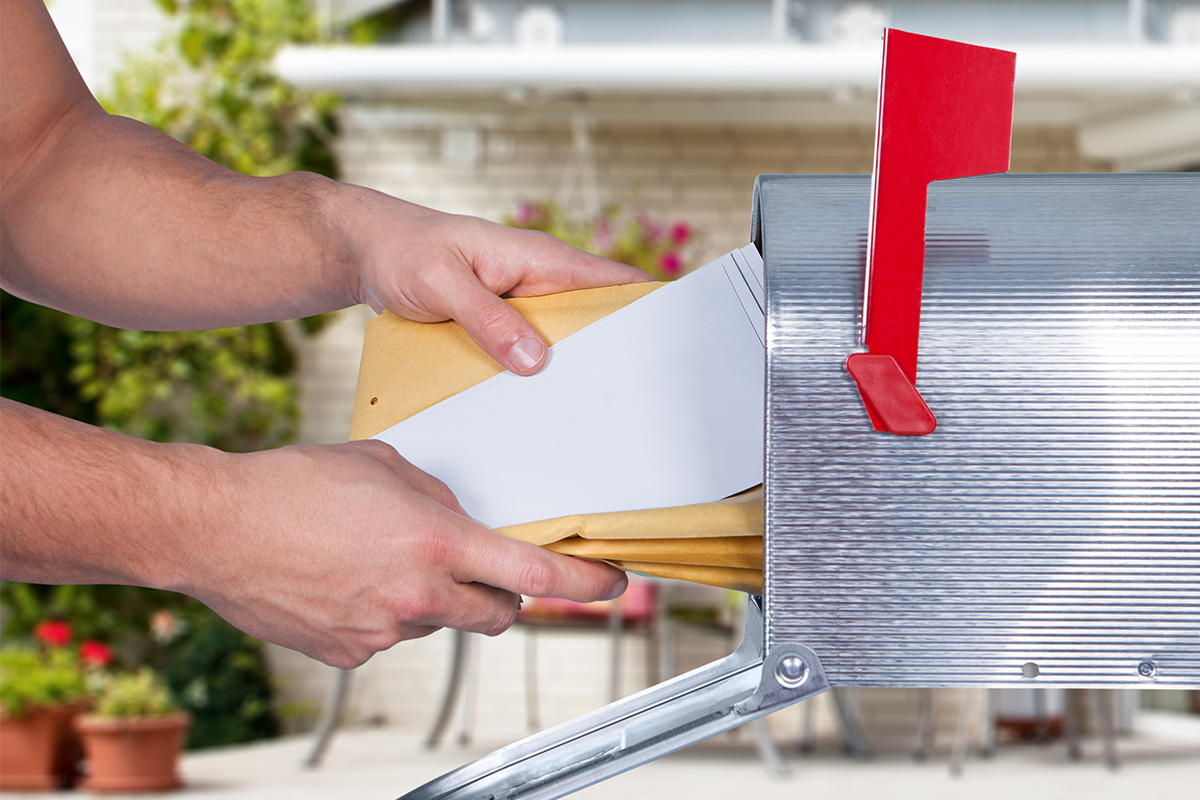 Man opening his mailbox to remove mail